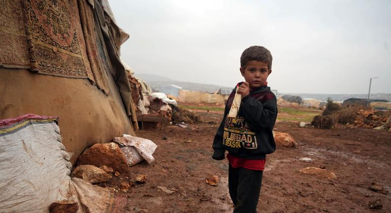 A young boy stands outside a shelter in a camp for displaced people in northern Syria.